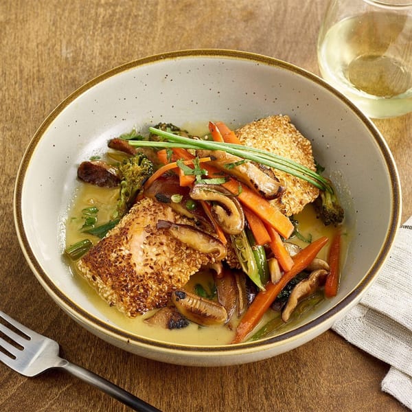 A Votre Santé's sesame-crusted fish with sautéed carrots, mushrooms, broccoli, and snap peas in a light sauce.