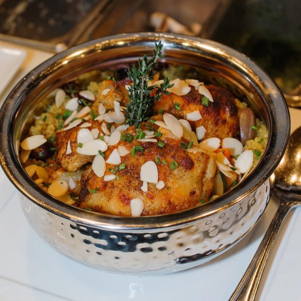 A Votre Santé's healthy chicken dish with almonds, chives, and thyme in a hammered metal bowl.