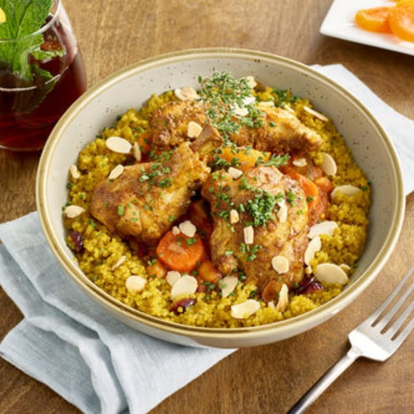 A Votre Santé's chicken tagine with couscous, carrots, almonds, and herbs, served with iced tea.