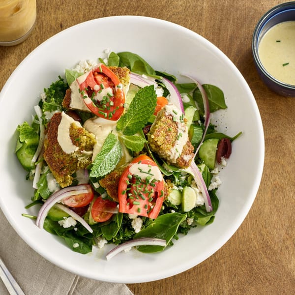 A Votre Santé's falafel salad with greens, tomatoes, onions, cucumbers, and feta cheese.