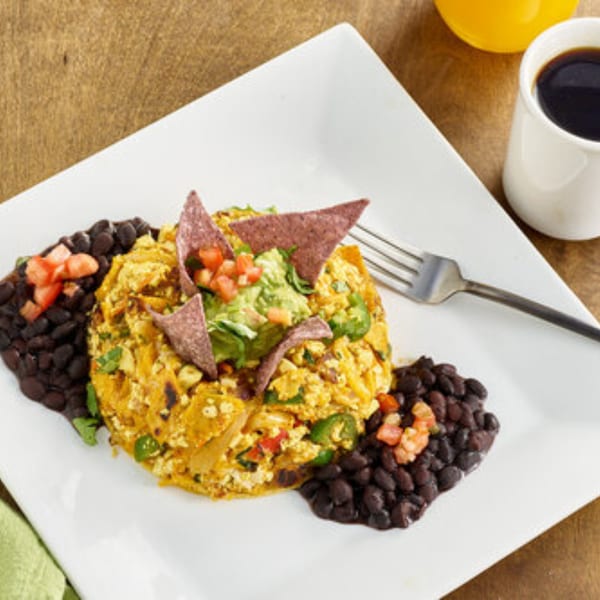 A Votre Santé's healthy breakfast scramble with black beans, guacamole, and tortilla chips.